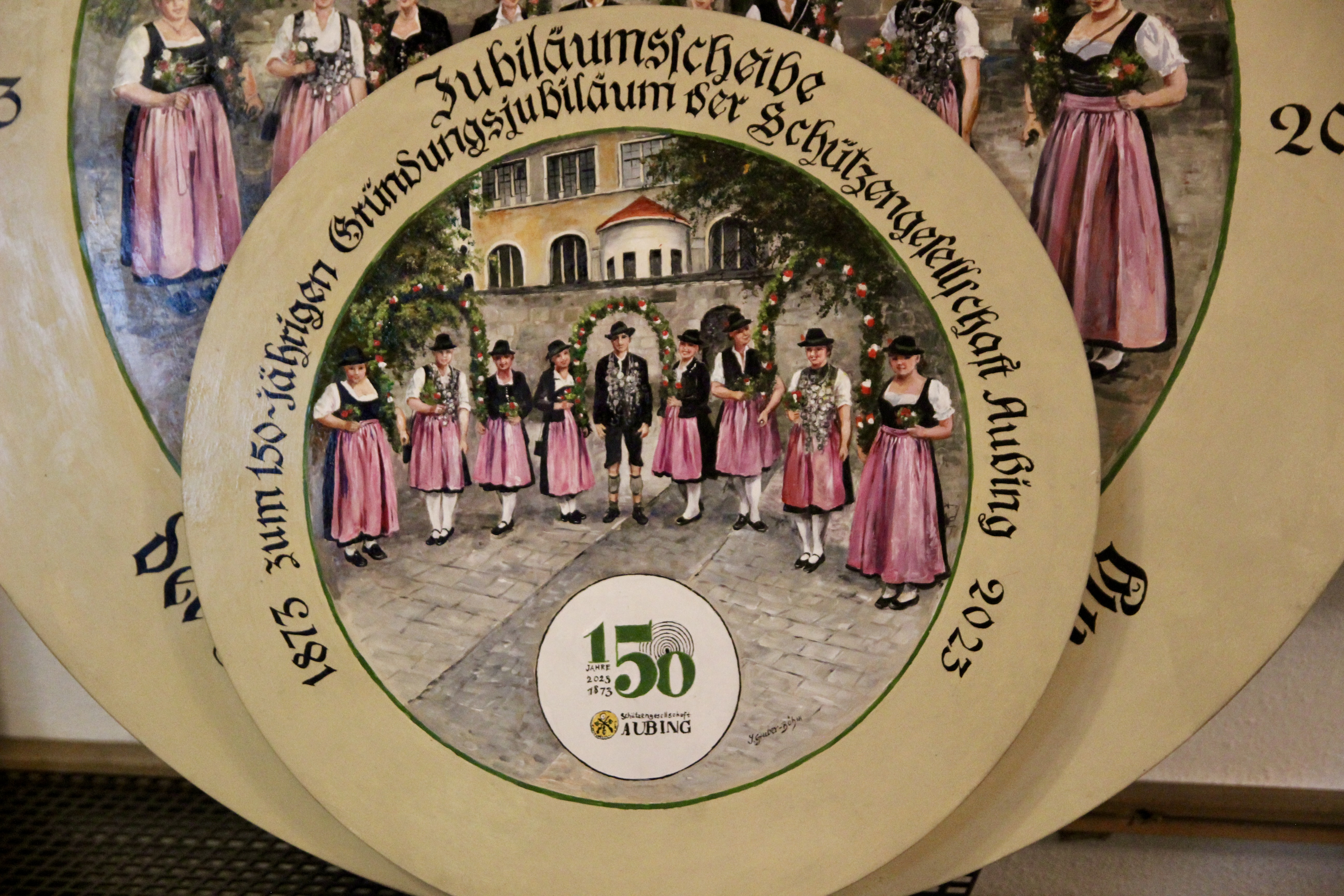 Die große und kleine Jubiläumstafel wurde von Inge Gruber-Böhm gemalt. Die große verbleibt im Vereinsheim, die Miniaturtafel darf der Sieger des Jubiläumsschießens nach Hause tragen, und zwar nach der festlichen Proklamation am 14. Mai.