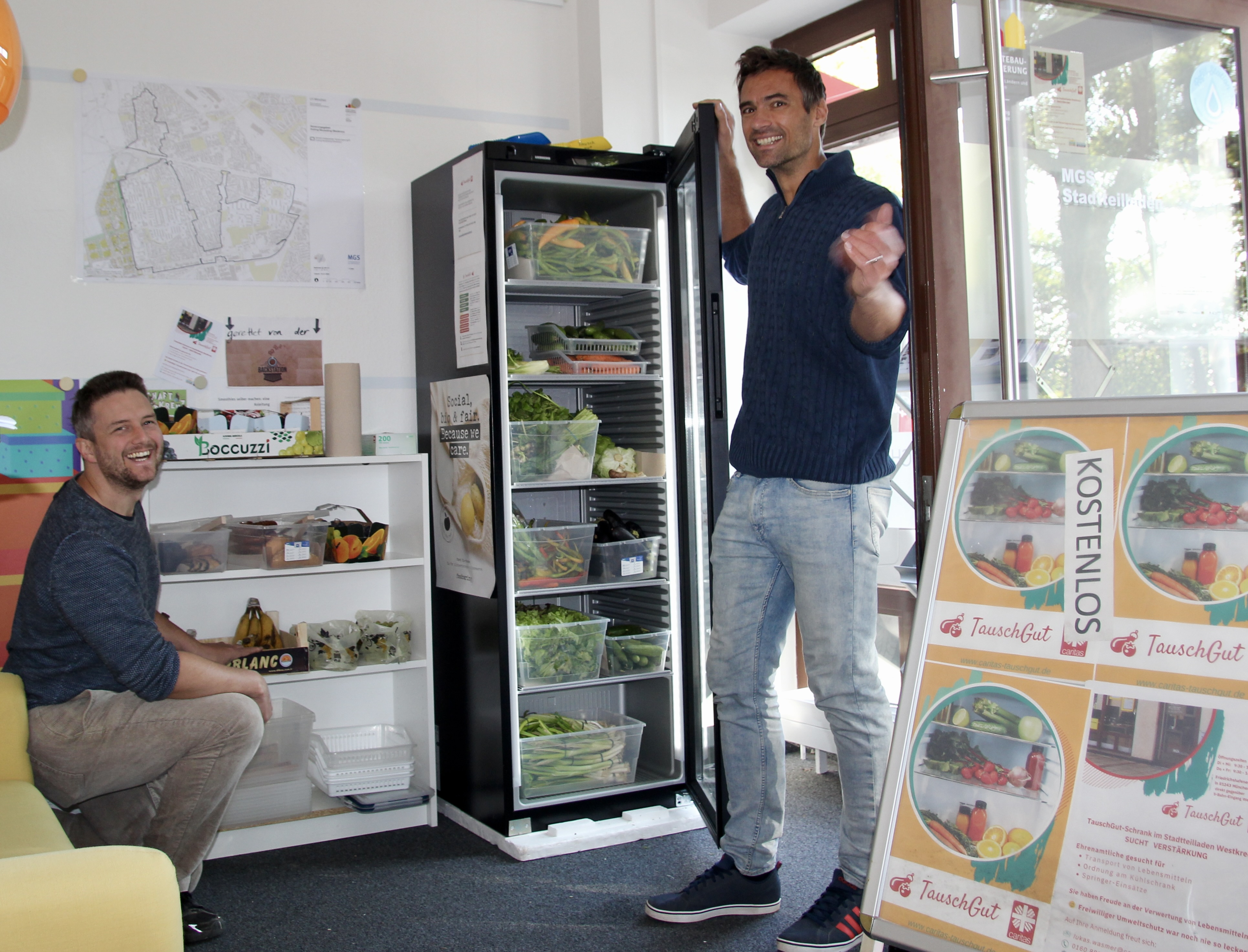 Lukas Wasmer und Martin Schumann (v.l.) am frisch gefüllten TauschGut-Kühlschrank im Stadtteilladen am Westkreuz.